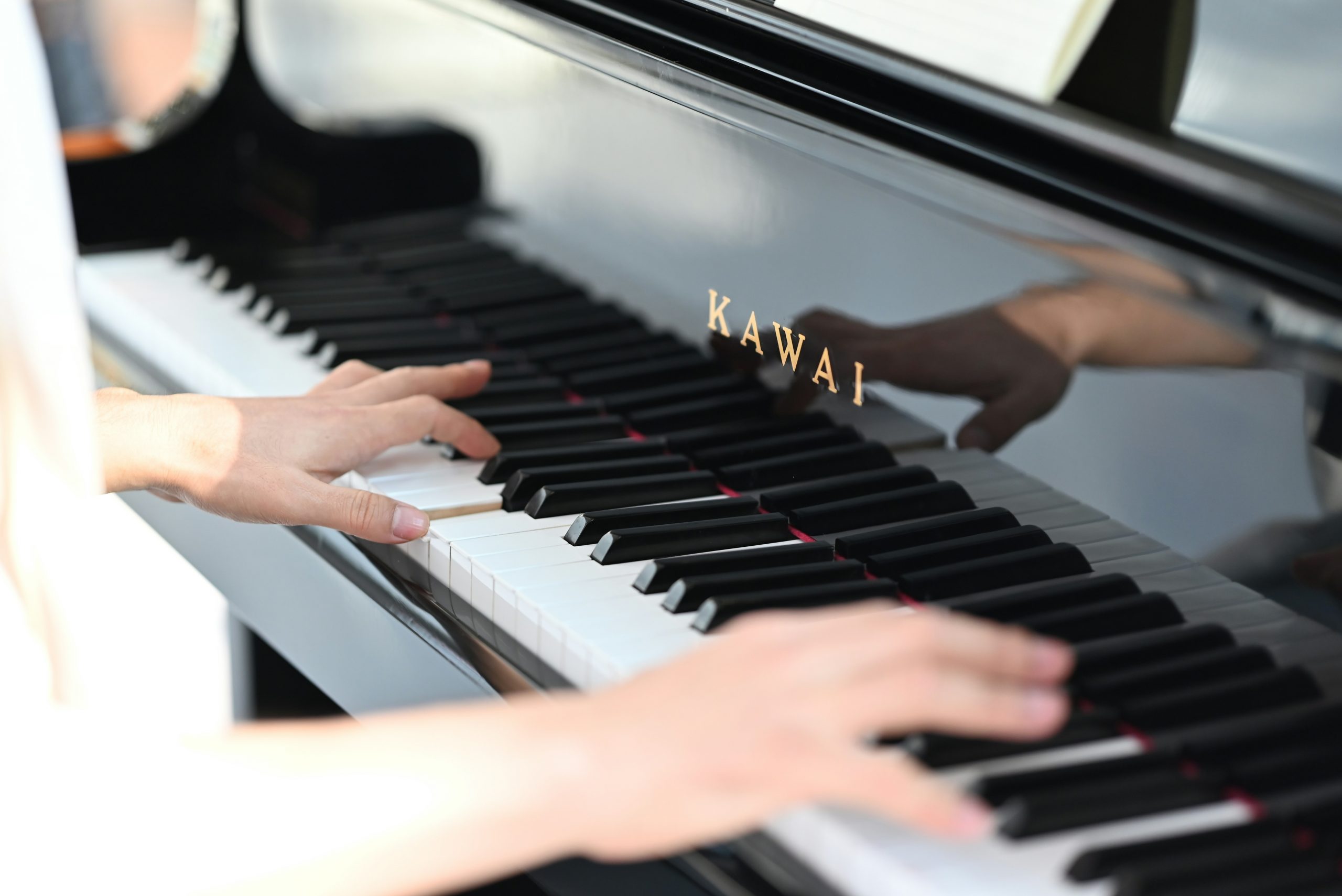Hands playing a Kawai piano during a one-to-one lesson in Derby